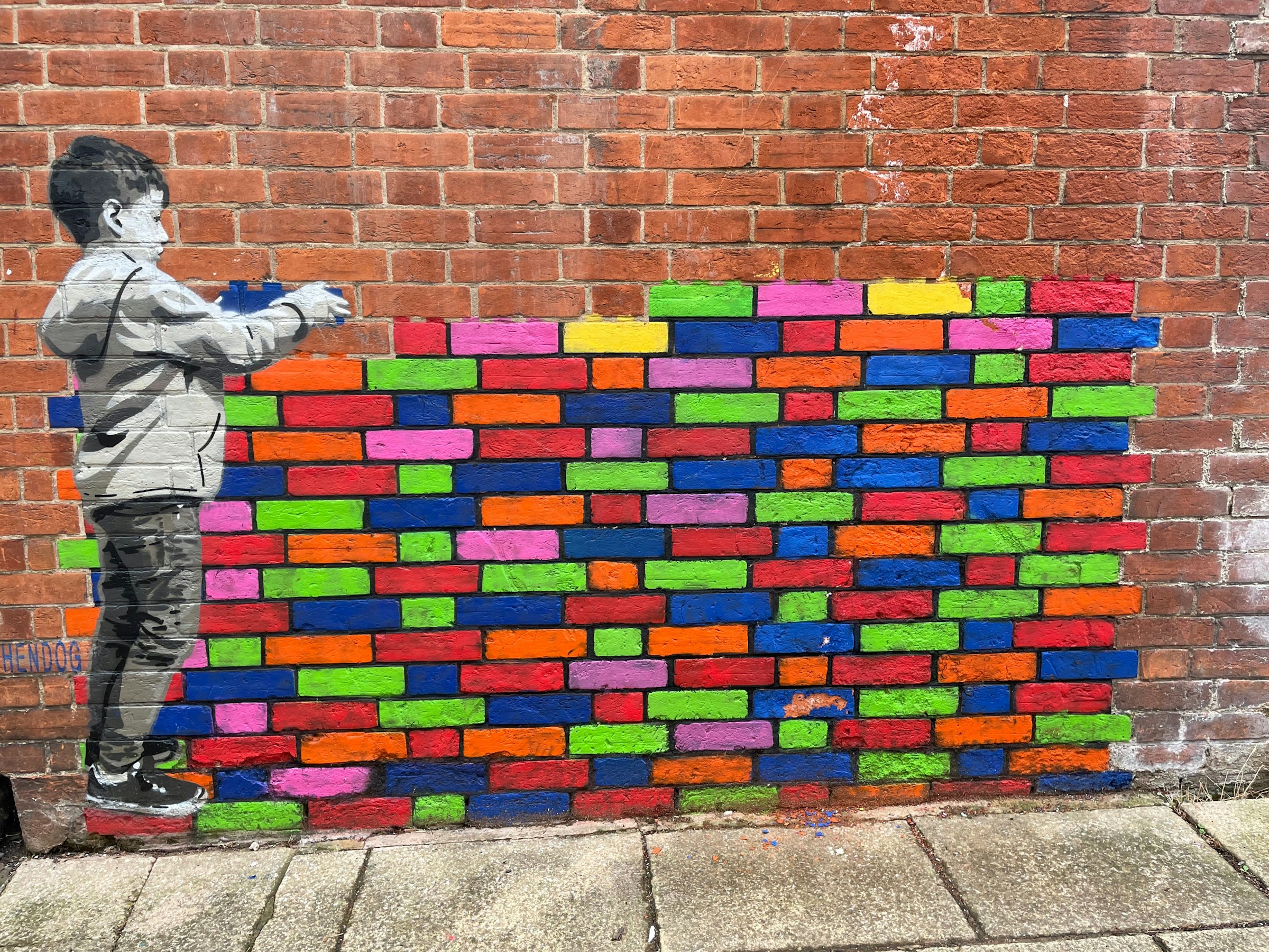 Freelance for Good hero image showing a child painting a multicoloured brick wall